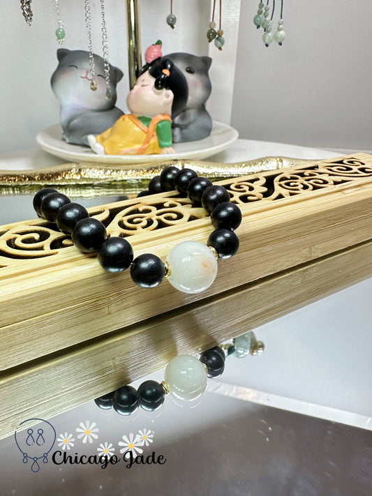 Large round white jadeite jade bead with orange highlights black wood beaded bracelet