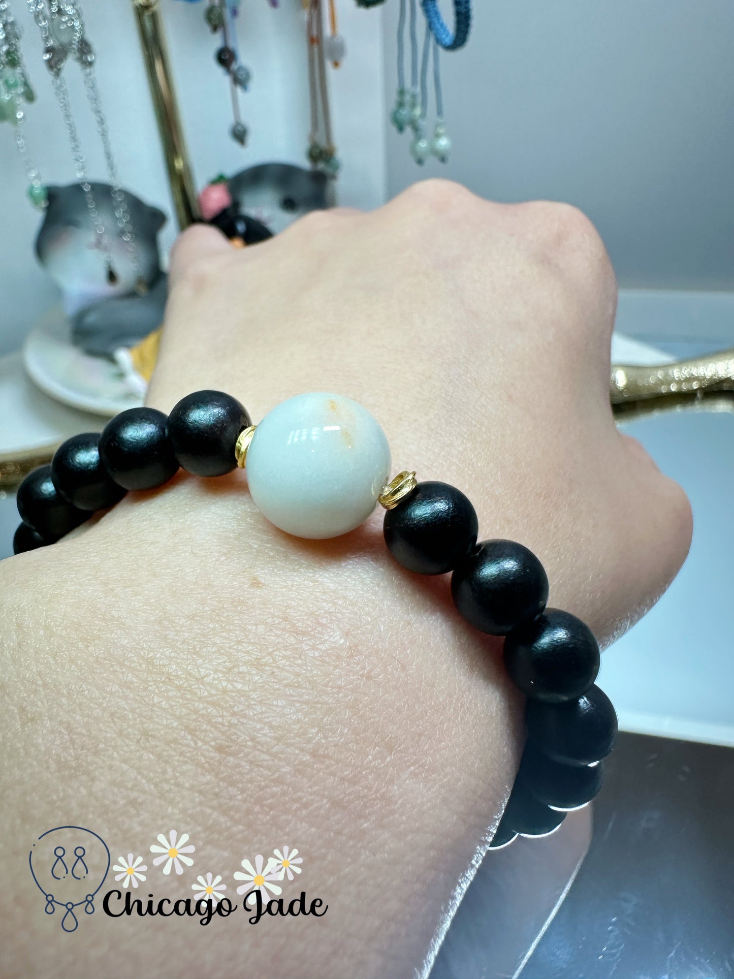 Large round white jadeite jade bead with orange highlights black wood beaded bracelet